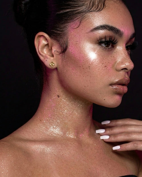 Mini clover gold stainless steel stud earrings on model ear – dainty everyday jewelry